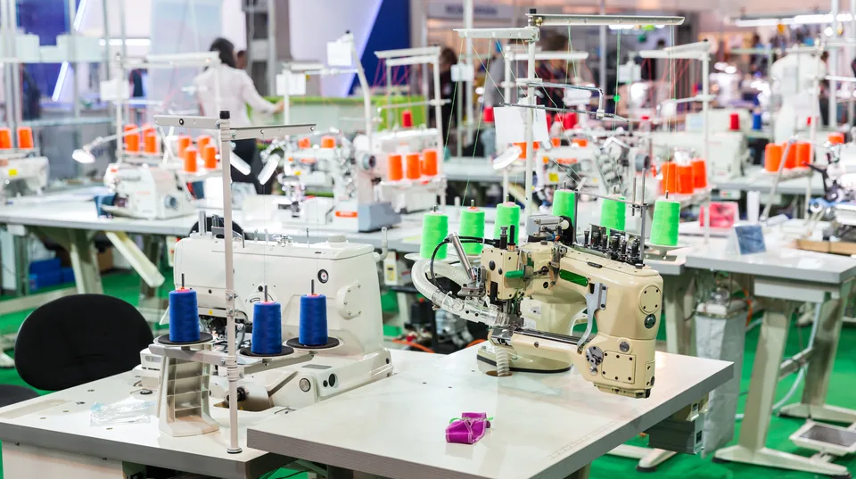 Rows of industrial sewing machines on a production floor