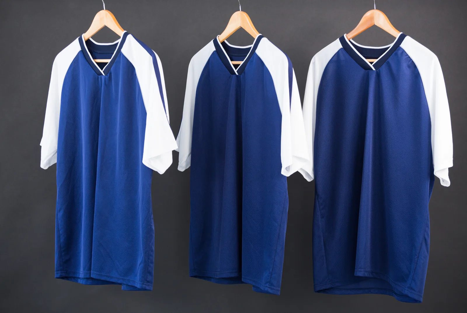 Three sports jerseys on hangers