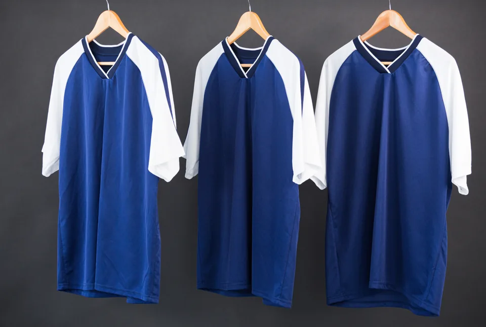 Three sports jerseys on hangers