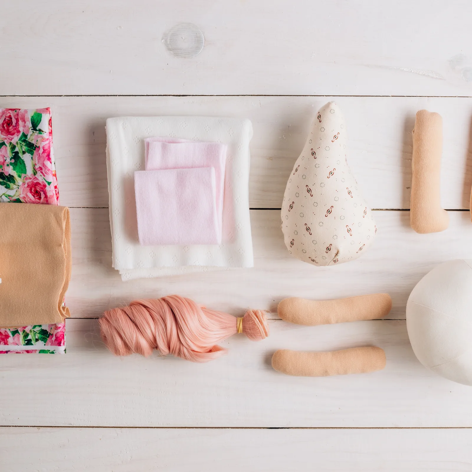 Fabric, stuffing and cut pieces laid out before a plush toy is sewn